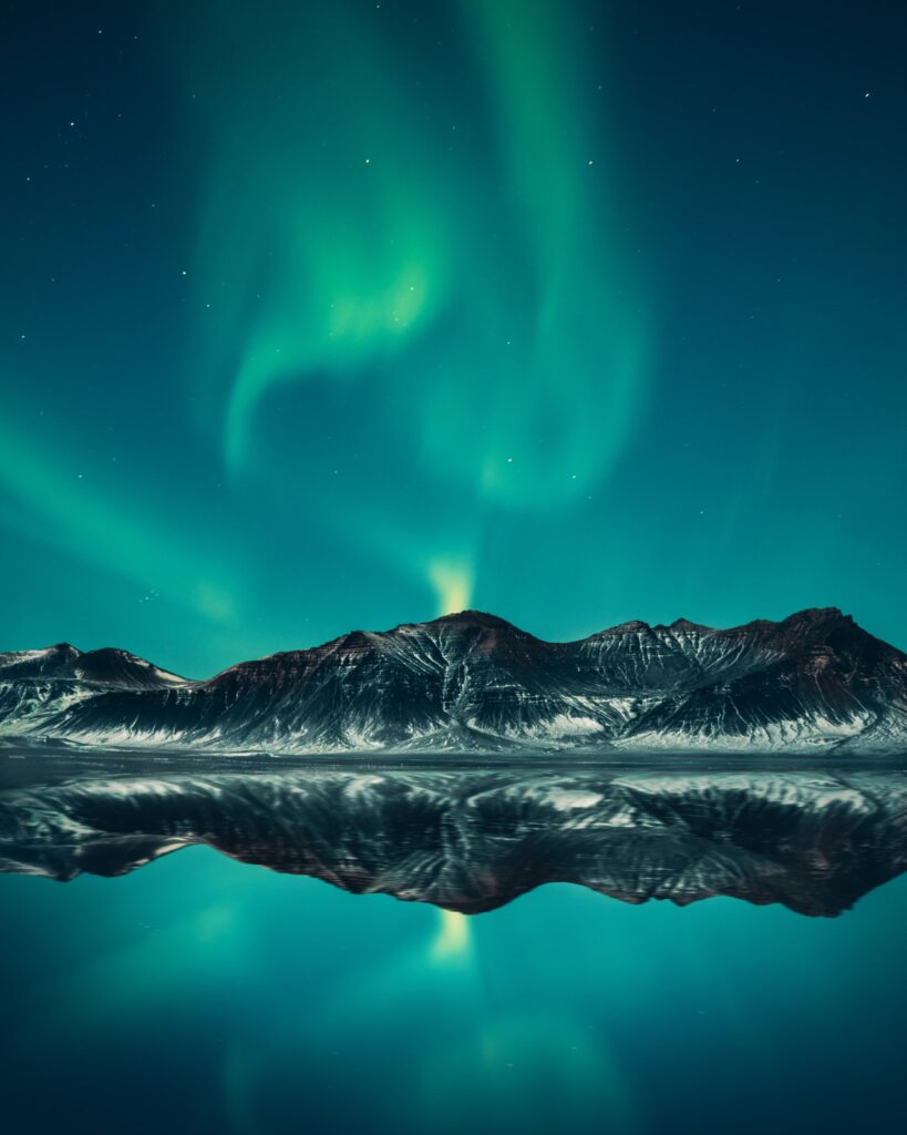 The Northern Lights over mountains and a lake