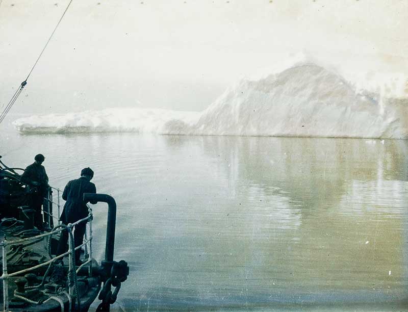 early polar expeditions sail past an iceberg on a ship