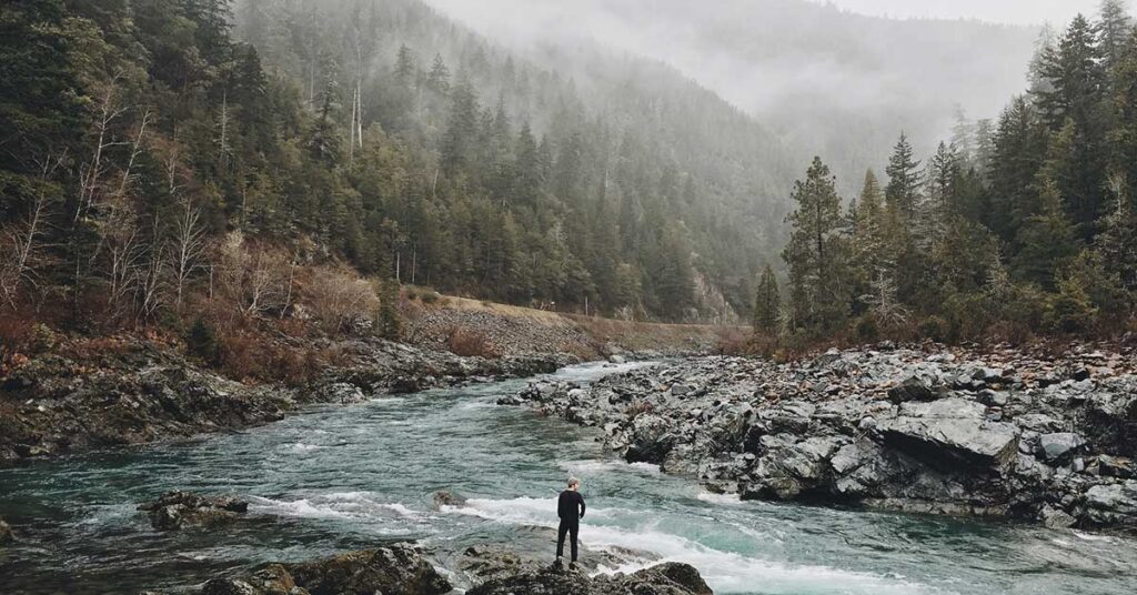 man by river in cloudy valley nature quotes newsletter