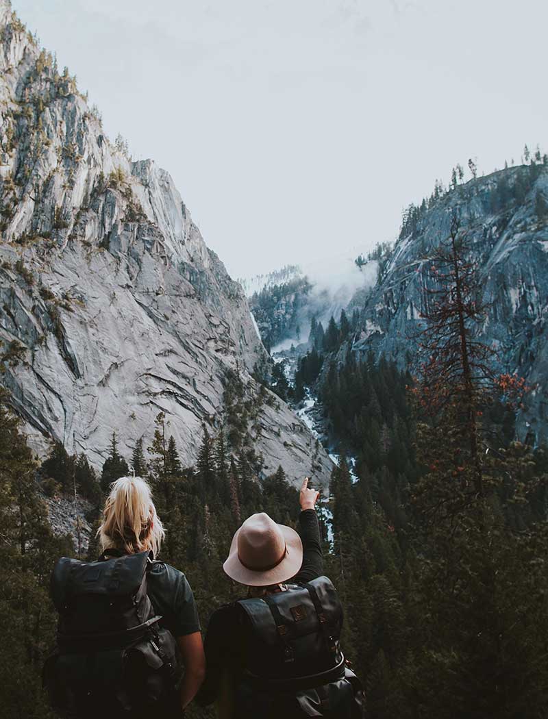 male and female hiker exploring through forest and mountains.