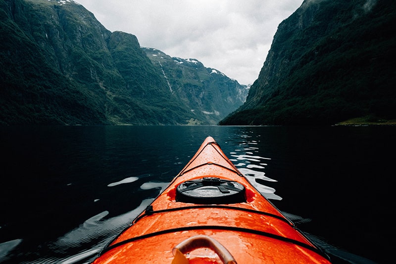 Kayak on dark lake with mountains