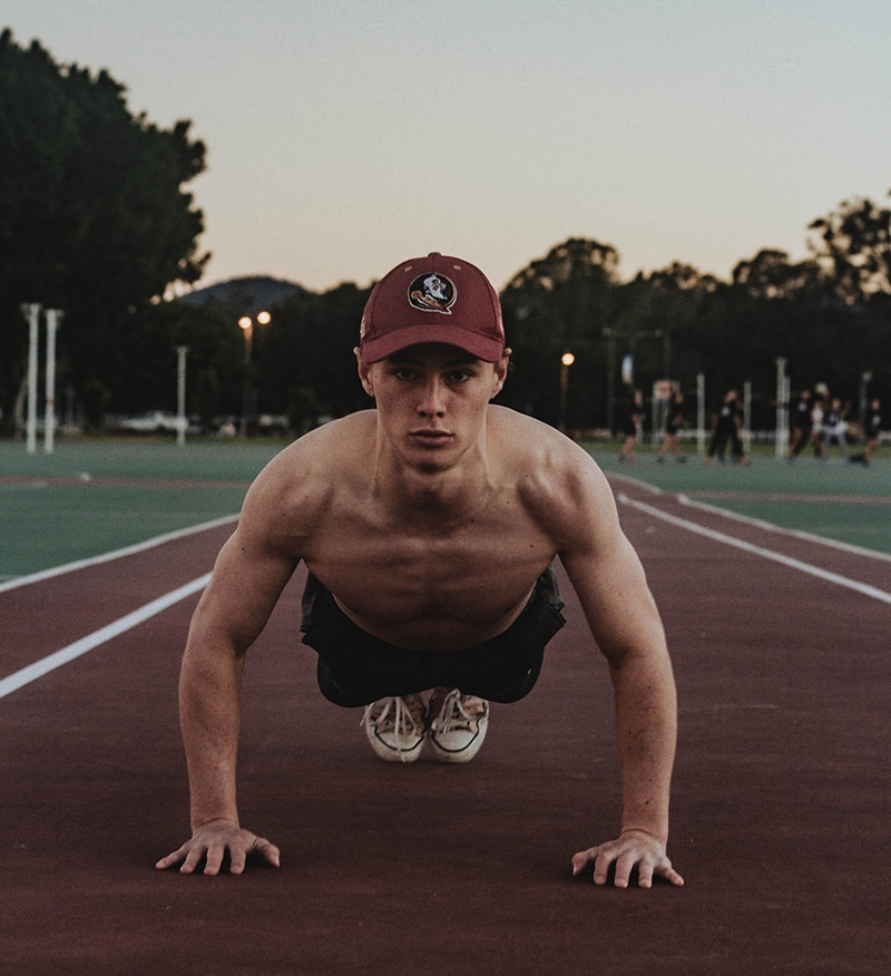 Push Up Workouts by male athlete on running track