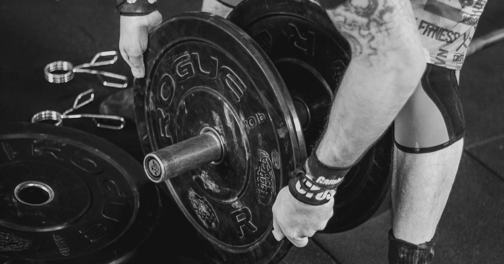 Man loading barbell for Landmine Row