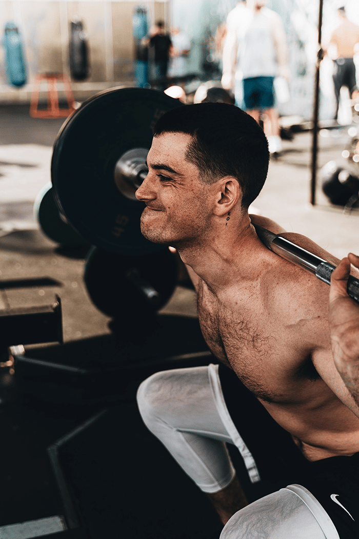 Man squatting with Barbell in gym