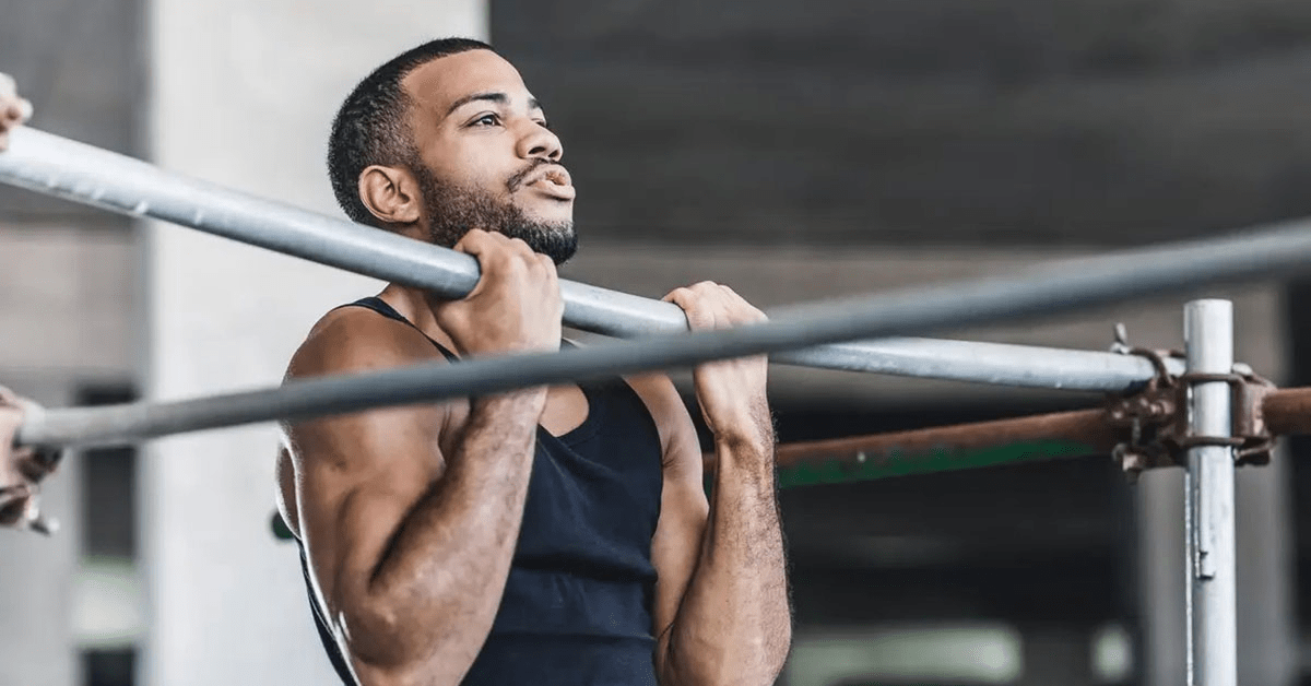 Male athlete performs chin up