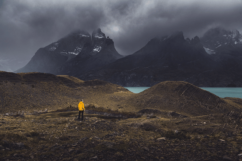 Man in wilderness with sea and mountains