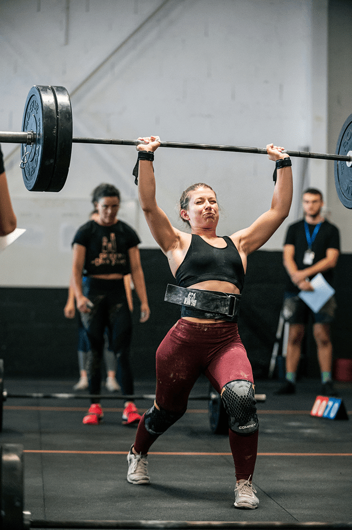 Woman doing clean and jerk with barbell
