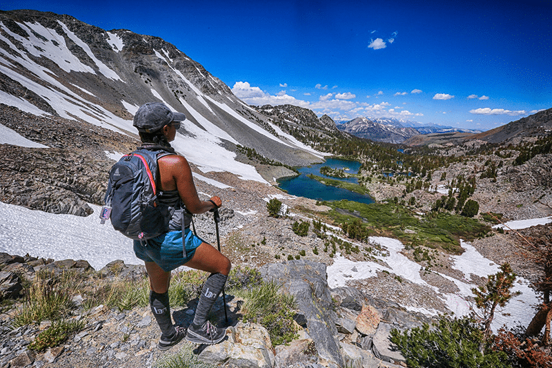 Woman on trail next to mountain lake