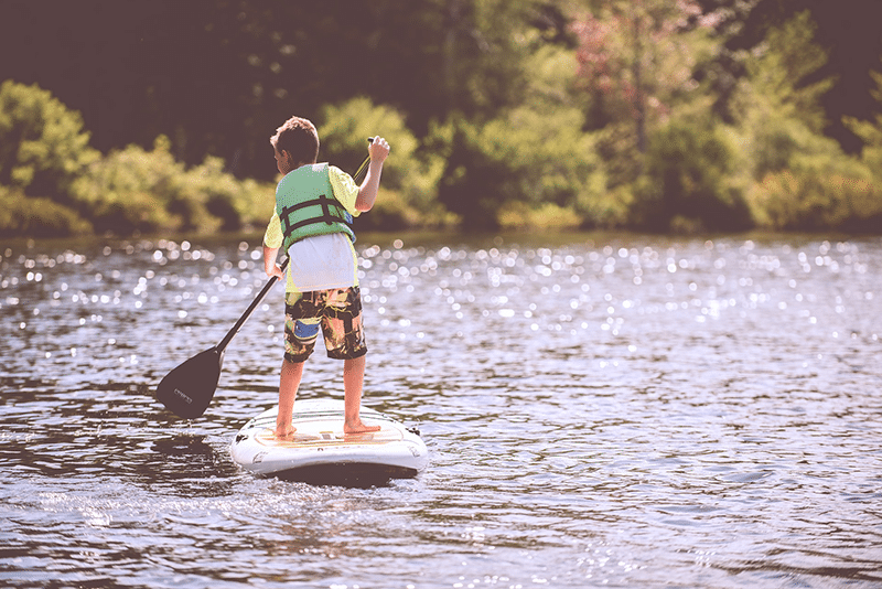 Young boy doing workout on paddleboard