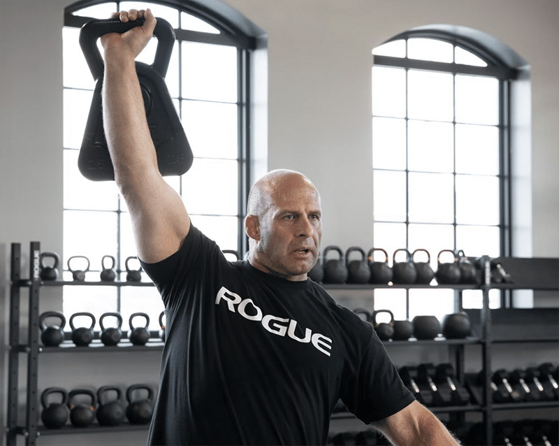 Man working out and lifting Mutt cowbells