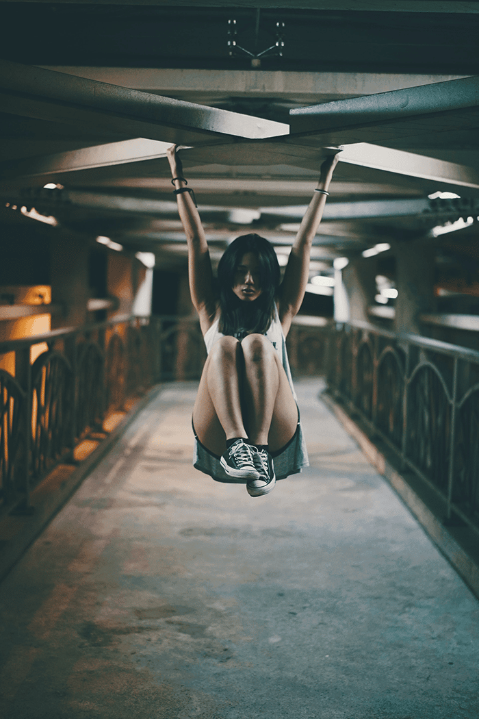 Woman hanging on metal bridge