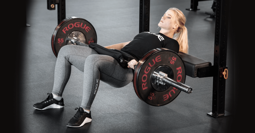 Woman with hip thrust bench and barbell in action