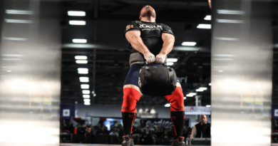 man lifting rogue strongman throw bag