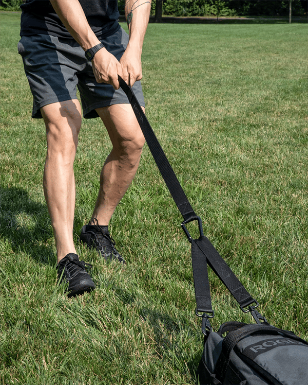 Man dragging weight on grass