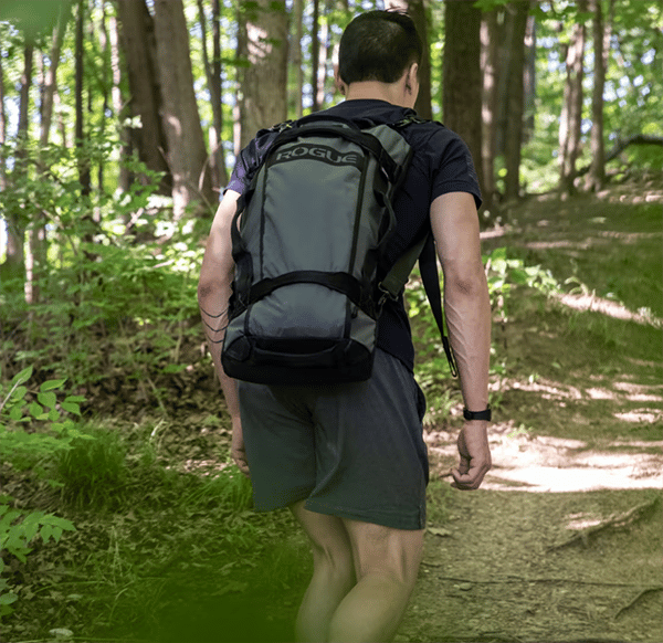 Man in woods with sandbag backpack
