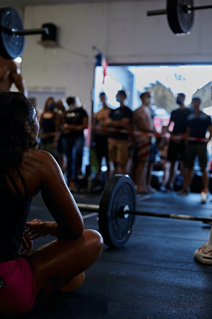 Woman sitting on gym floor after weightlifting