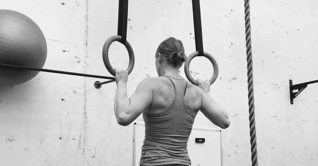 Woman doing pull ups on rings