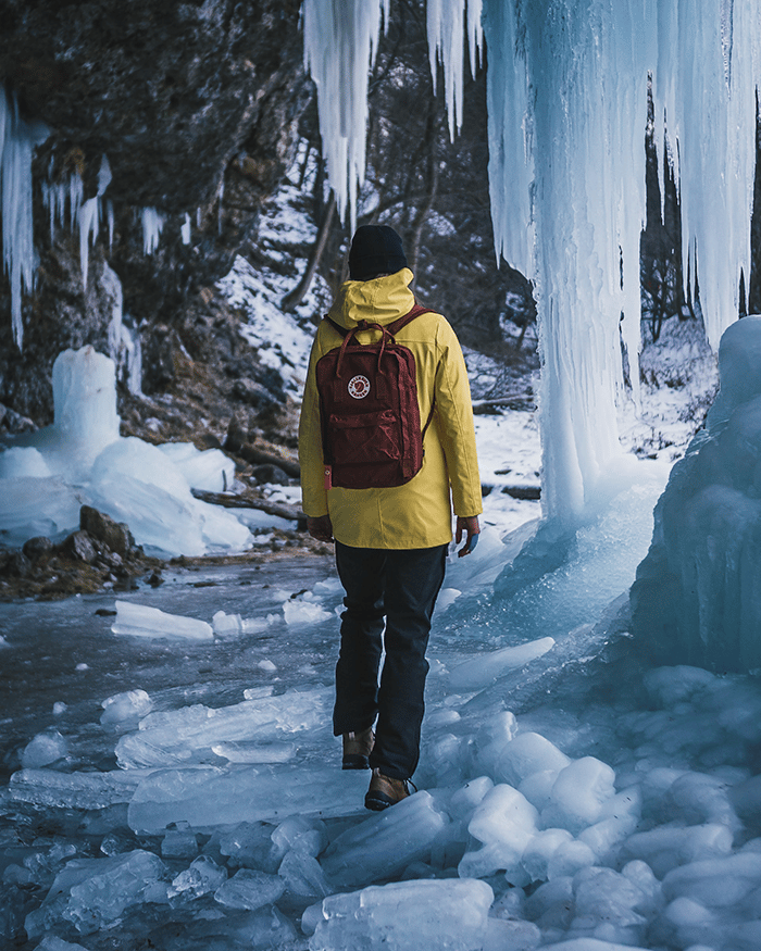 Hiker walking through ice cave