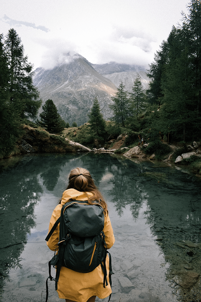 Woman next to lake with hiking apps