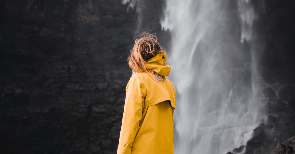 Woman next to waterfall