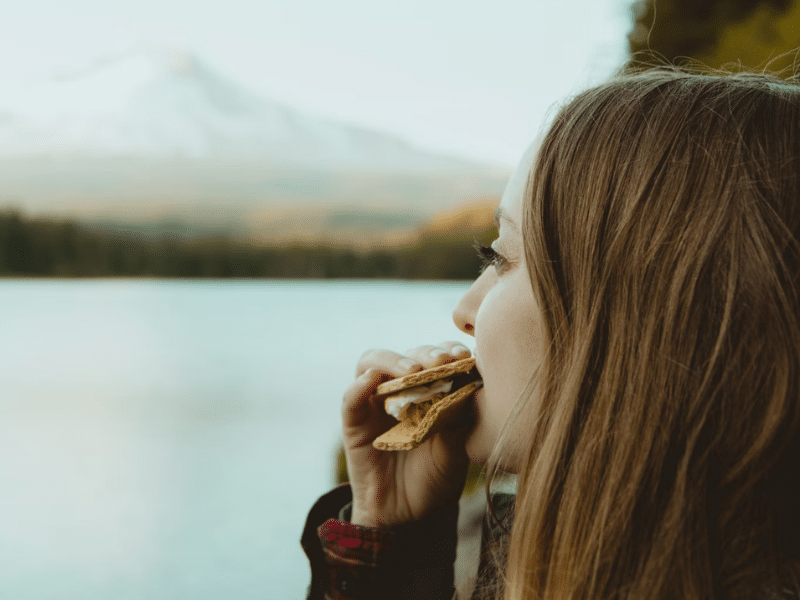 Camper eats a marshmallow s'more