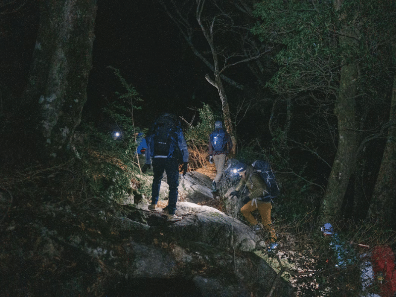 Hikers head uphill at night